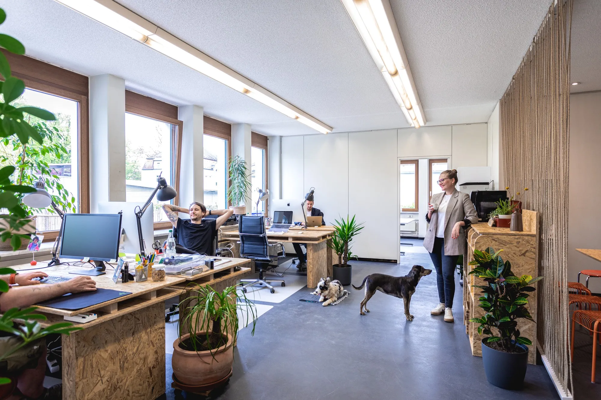 Offener Coworking-Bereich mit mehreren Arbeitsplätzen und arbeitenden Menschen